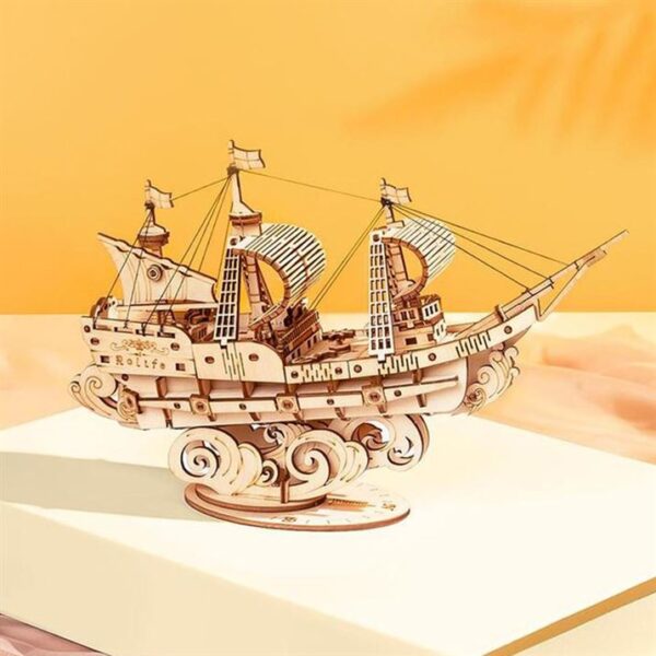 Un modÃ¨le en bois de puzzle 3d rokr d'un bateau pirate perchÃ© au sommet d'un livre.