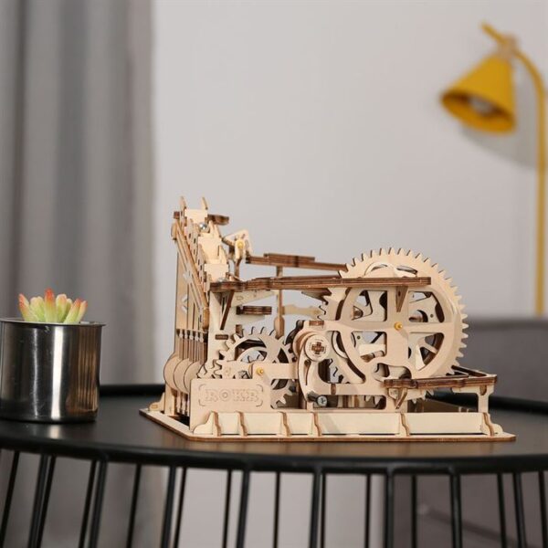 Un modÃ¨le de puzzle 3d en bois rokr d'une machine affichÃ©e sur une table.