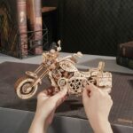 Quelqu'un crée une maquette en bois d'une moto.