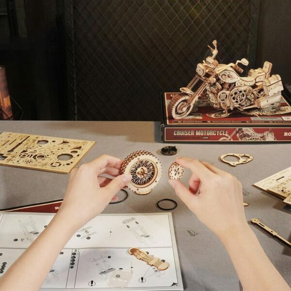 Une personne construit une maquette en bois d'une moto.