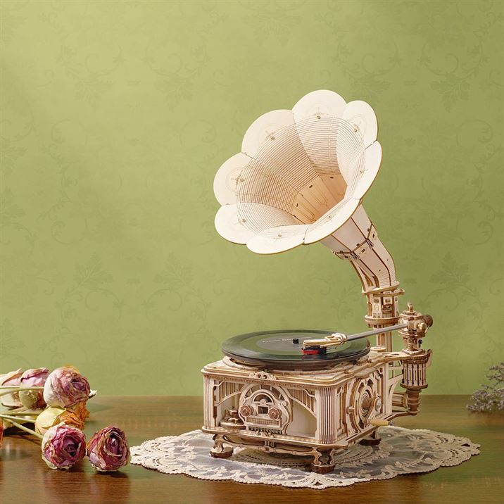 Une maquette de puzzle en bois 3d représentant un gramophone avec des fleurs sur une table.