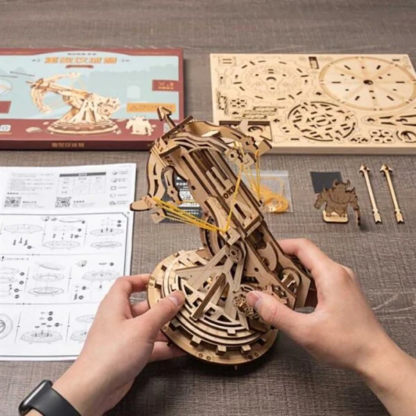 Une personne assemble un puzzle 3d reprÃ©sentant une horloge modÃ¨le en bois crÃ©Ã©e par robotime.