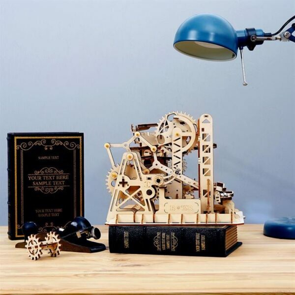Une maquette rokr en bois d'une machine et d'un livre sur un bureau.