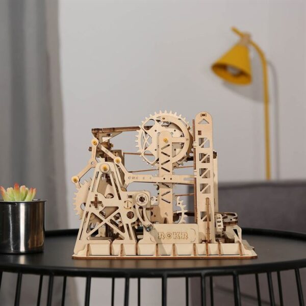 Un modÃ¨le de puzzle en bois 3d d'une machine exposÃ©e sur une table, conÃ§u par rokr pour les passionnÃ©s de puzzfever.