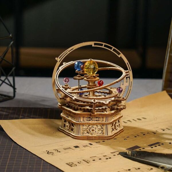 Un modèle de puzzle 3d en bois représentant une planète placée sur une partition de musique, rokr.