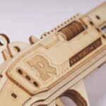 Une maquette puzzle 3D d'un pistolet en bois avec la lettre "r" dessus.