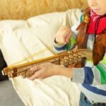 Un jeune garçon jouant avec un pistolet-jouet en bois Rokr.