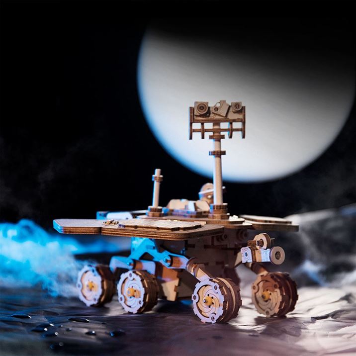 Une maquette d'un rover avec une lune en arrière-plan.