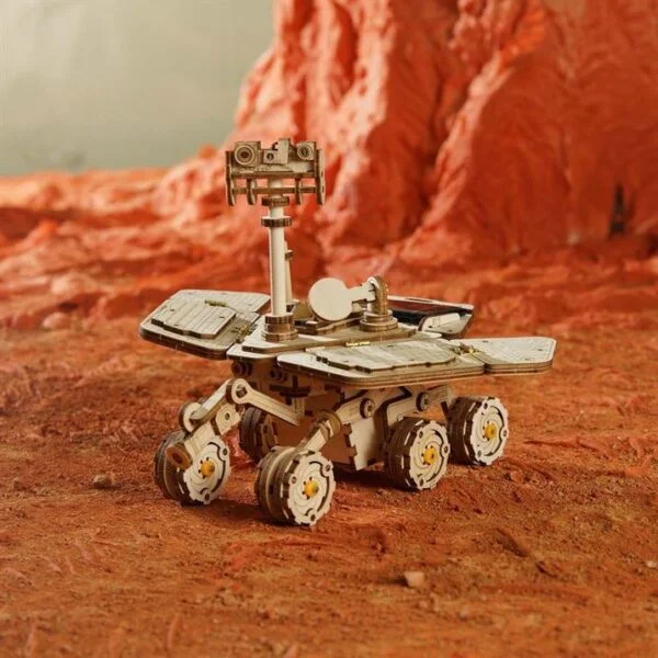 Une maquette de rover robotique sur un dÃ©sert rouge.