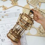 Une personne crée un modèle en bois d'une lanterne à l'aide de la maquette Robotime.