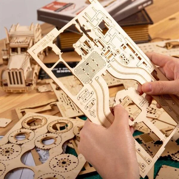 Une personne assemble une maquette de robotime en bois.