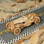 Un modèle de puzzle en bois 3D représentant une voiture de course sur une route en damier.