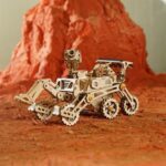 Une maquette de rover sur un rocher rouge.