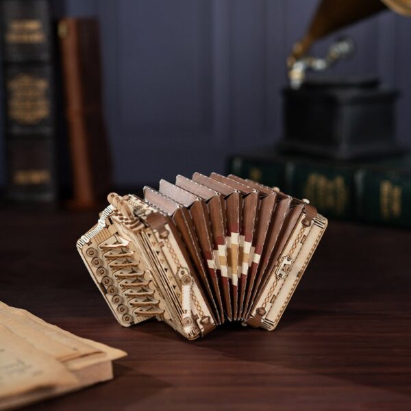 Une maquette d'accordéon en bois posée sur une table.