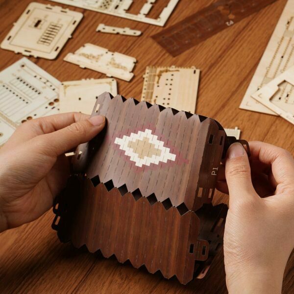 Une personne fabrique une boîte de puzzle en bois 3d.