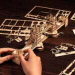 Une personne crée une maquette en bois du Tower Bridge.