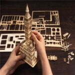 Description (modifiée) : Quelqu'un assemble un modèle 3D de puzzle en bois de Big Ben.