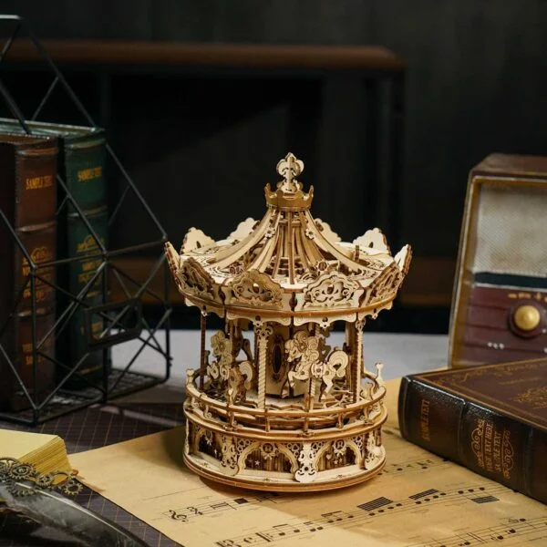 Un carrousel musical en bois avec puzzle 3D est posé sur une table à côté de livres.
