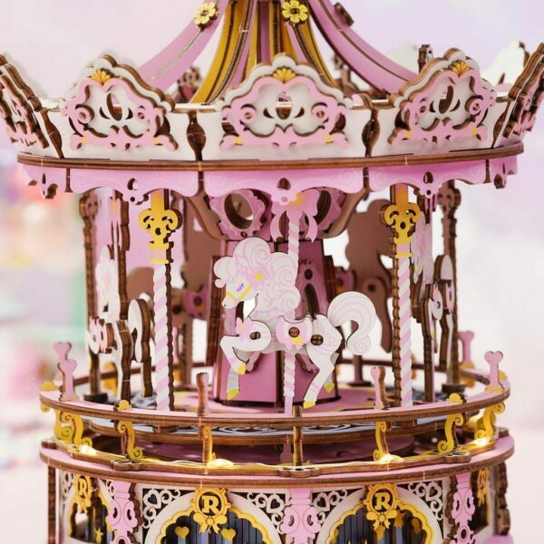 Une maquette rose et or du carrousel musical enchantÃ© est rÃ©alisÃ©e en papier.