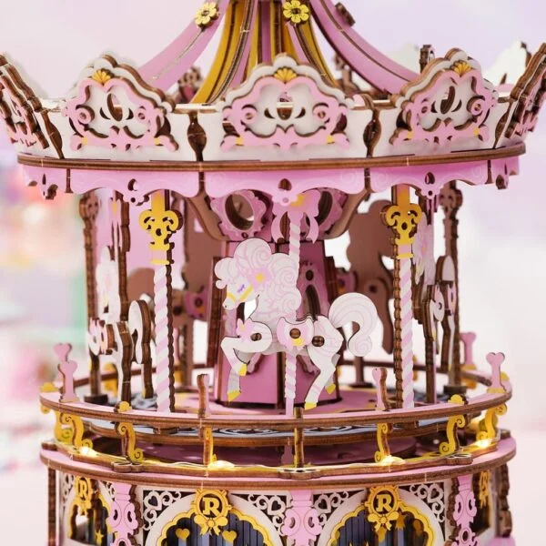 Une maquette rose et or du Carrousel musical enchanté est réalisée en papier.