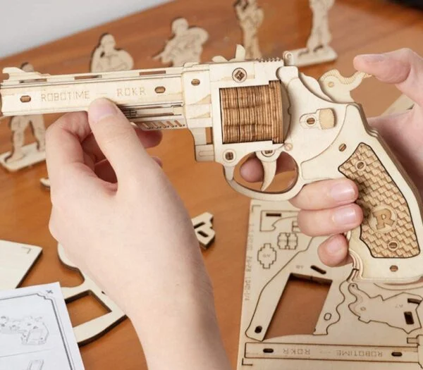Une personne assemble un puzzle 3D de la collection Robotime sur une table.