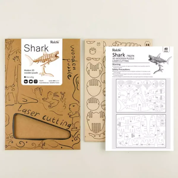 Une boÃ®te Ã  maquette avec un kit de dÃ©coupe rokr puzzle 3d requin et un dessin d'un requin.