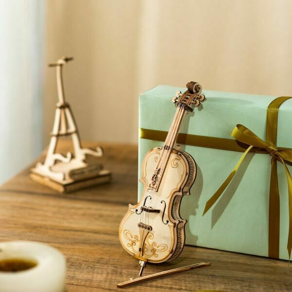 Un rokr - cello en bois est posé sur une table à côté d'un cadeau.