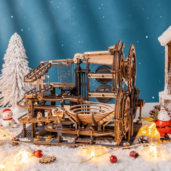 Une maquette en bois d'une machine de noël exposée devant un fond enneigé, parfaite pour des idées de cadeaux de noël uniques.