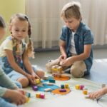 Un groupe d'enfants jouant avec des puzzles éducatifs au sol à différents âges.